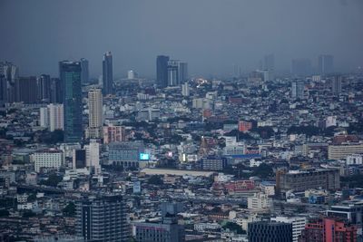 Aerial view of buildings in city against sky