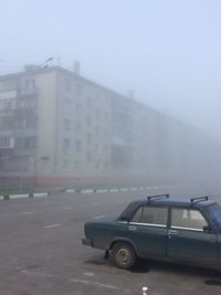 Car on street against buildings in city