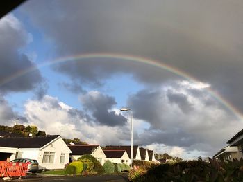 Rainbow over building against sky