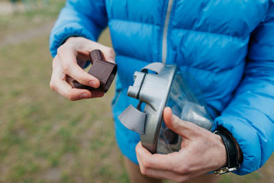 Midsection of man holding mobile phone