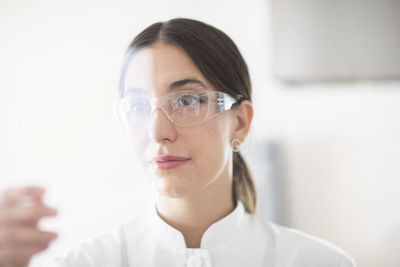 Scientist female with lab glasses, tablet and sample in a lab