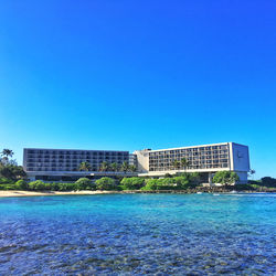 Calm blue sea with buildings in background