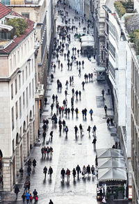 High angle view of people walking on street amidst buildings in city