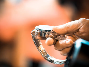 Close-up of hand holding wristwatch