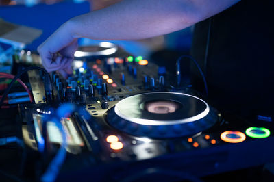 Cropped hand of dj using sound mixer