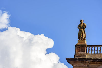 Low angle view of statue against blue sky