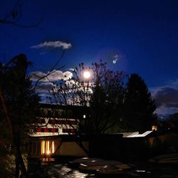 Illuminated street light against sky at night