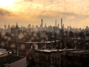 Buildings in city against sky during sunset