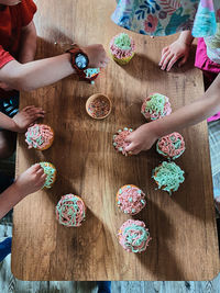 Group of children baking cupcakes, preparing ingredients, topping, sprinkles for decorating cookies