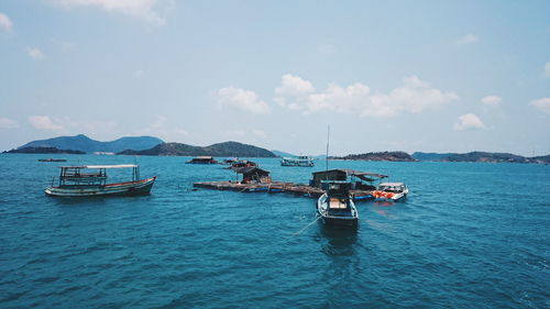 View of boats moored in calm blue sea