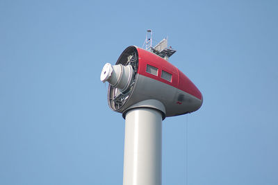 Low angle view of communications tower against clear blue sky