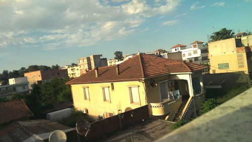 Railroad tracks by buildings in city against sky