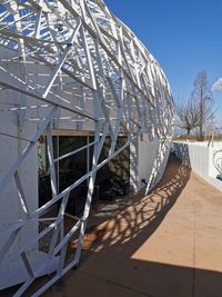 Metallic structure on footpath against sky