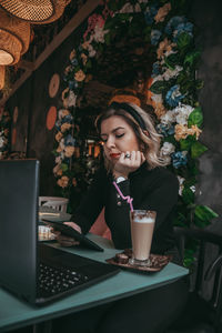 Woman looking at camera while sitting on table