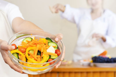 Midsection of woman holding ice cream in bowl