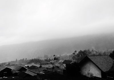 High angle view of houses in town against sky