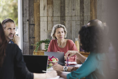 Businesswoman looking at colleagues during meeting in portable office truck