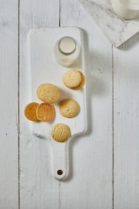 Directly above shot of cookies by milk in bottle on table