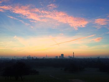 Silhouette city against sky during sunset