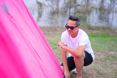 Man arranging tent on land