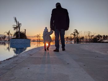 Rear view of father with daughter during sunset