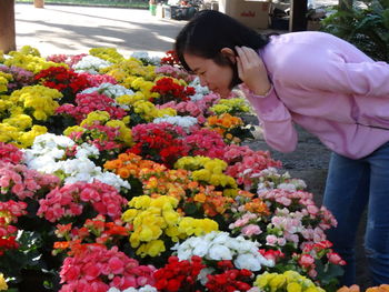 Young woman with flowers in market stall