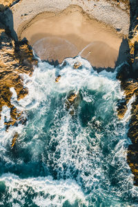 Aerial image of waves hitting the coastline of the french island corse near the village lumio.