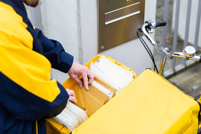 Midsection of man working by yellow container