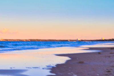 Scenic view of beach against sky during sunset