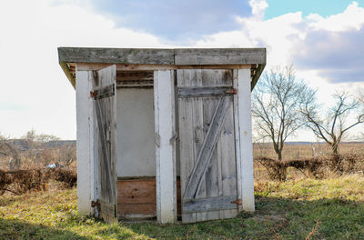 Old barn on field against sky