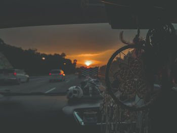 Cars on road against sky during sunset