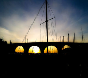 Silhouette bridge against sky during sunset