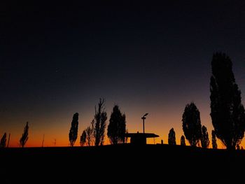 Low angle view of silhouette trees against clear sky at night