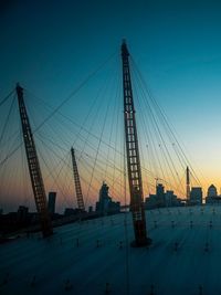 Low angle view of cranes at dusk