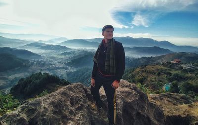 Portrait of man standing on mountain against sky