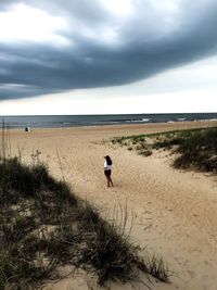 Girl on beach against sky