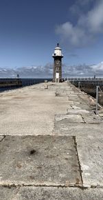 Lighthouse by sea against sky