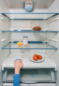 Cropped hand holding food in refrigerator