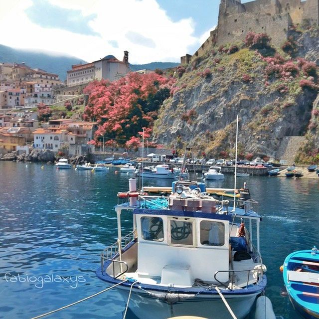 nautical vessel, transportation, boat, mode of transport, moored, water, building exterior, sky, built structure, architecture, sea, mountain, travel, waterfront, harbor, day, outdoors, incidental people, town, river