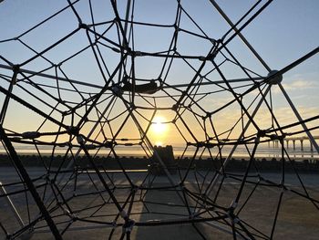 Silhouette metallic structure against sky during sunset