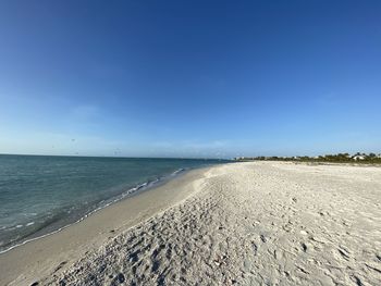 Scenic view of beach against blue sky