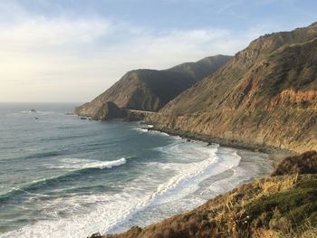 Scenic view of sea and mountains against sky