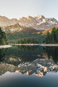 Scenic view of lake by mountains against clear sky