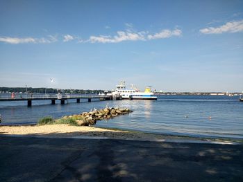 Ship moored at harbor against sky