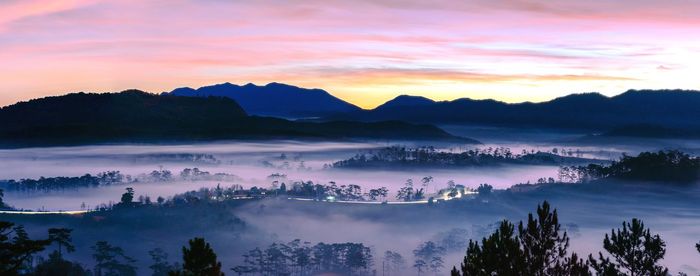 Panoramic view of silhouette mountains against sky during sunset