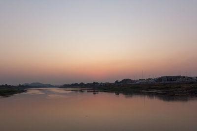 Scenic view of lake against clear sky during sunset