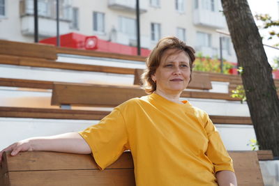 Portrait of a woman. a girl of european appearance on the street in the summer in a yellow t-shirt