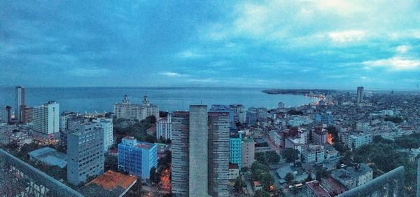 Aerial view of city against cloudy sky