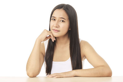 Portrait of beautiful young woman against white background