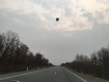 Road amidst trees against sky